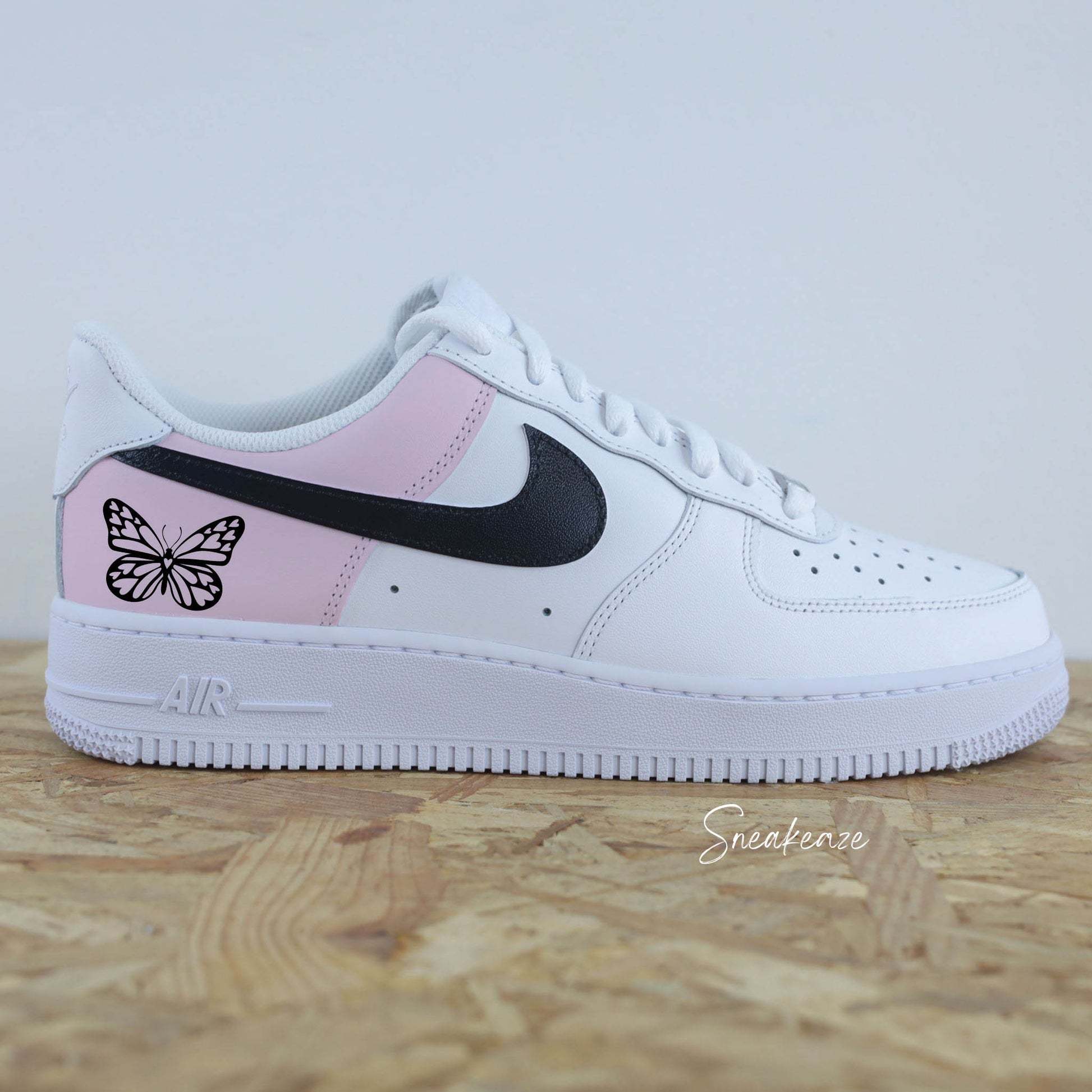 Baskets Nike Air Force 1 custom color block rose pastel avec signes nike peint en noir et papillon sneakeaze custom