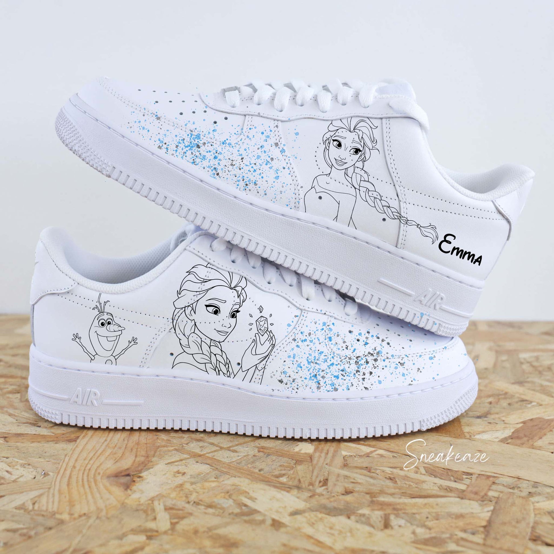 Baskets Nike Air force 1 custom - La reine des neiges. Motif Elsa et Olaf avec splash bleu ciel et et argenté sur les côtés extérieurs. Inscription du prénom sneakeaze customs