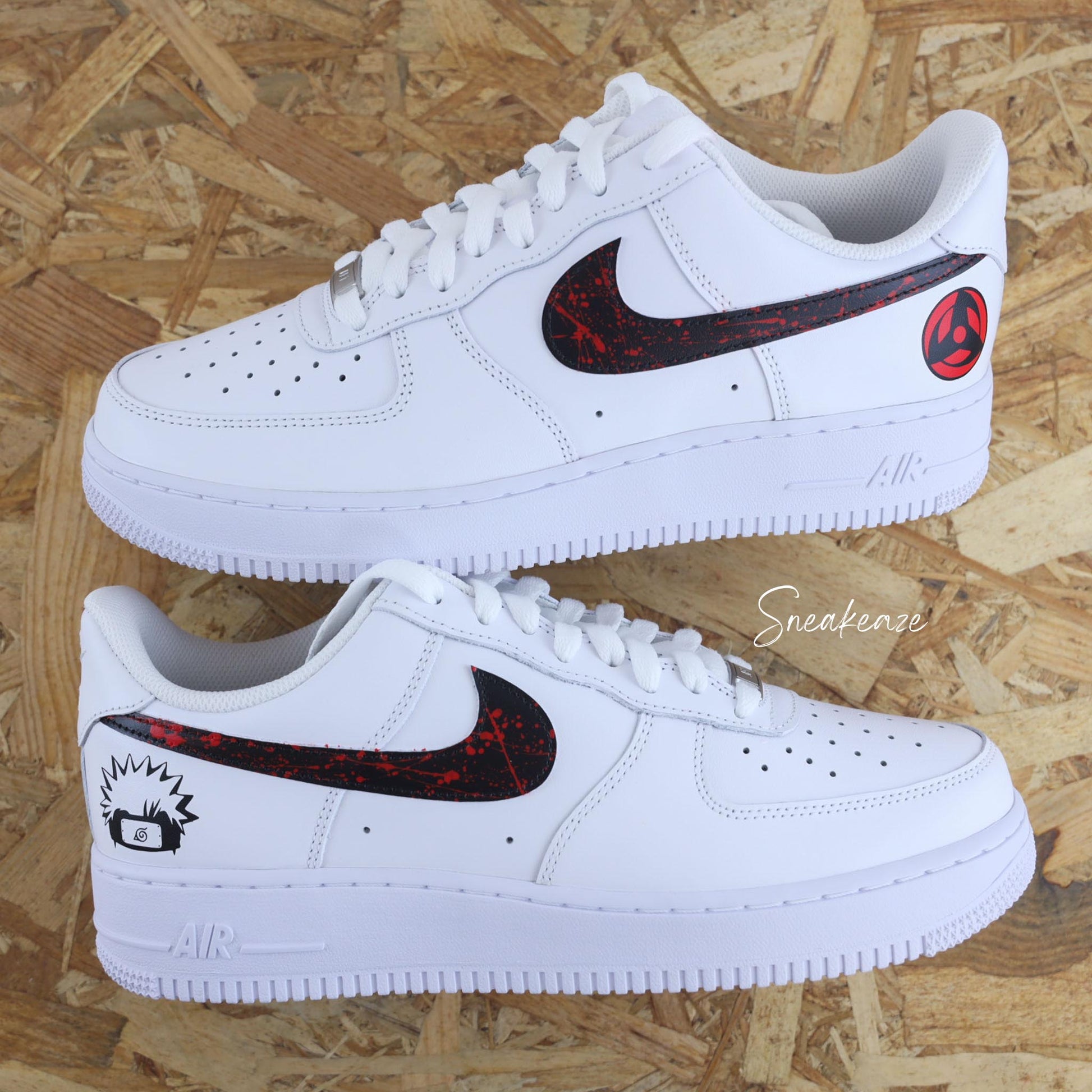 Nike Air Force 1 custom avec motifs Naruto sur les côtés extérieurs, swoosh noir et splash rouge intense — une paire unique pour les fans de manga et de sneakers.