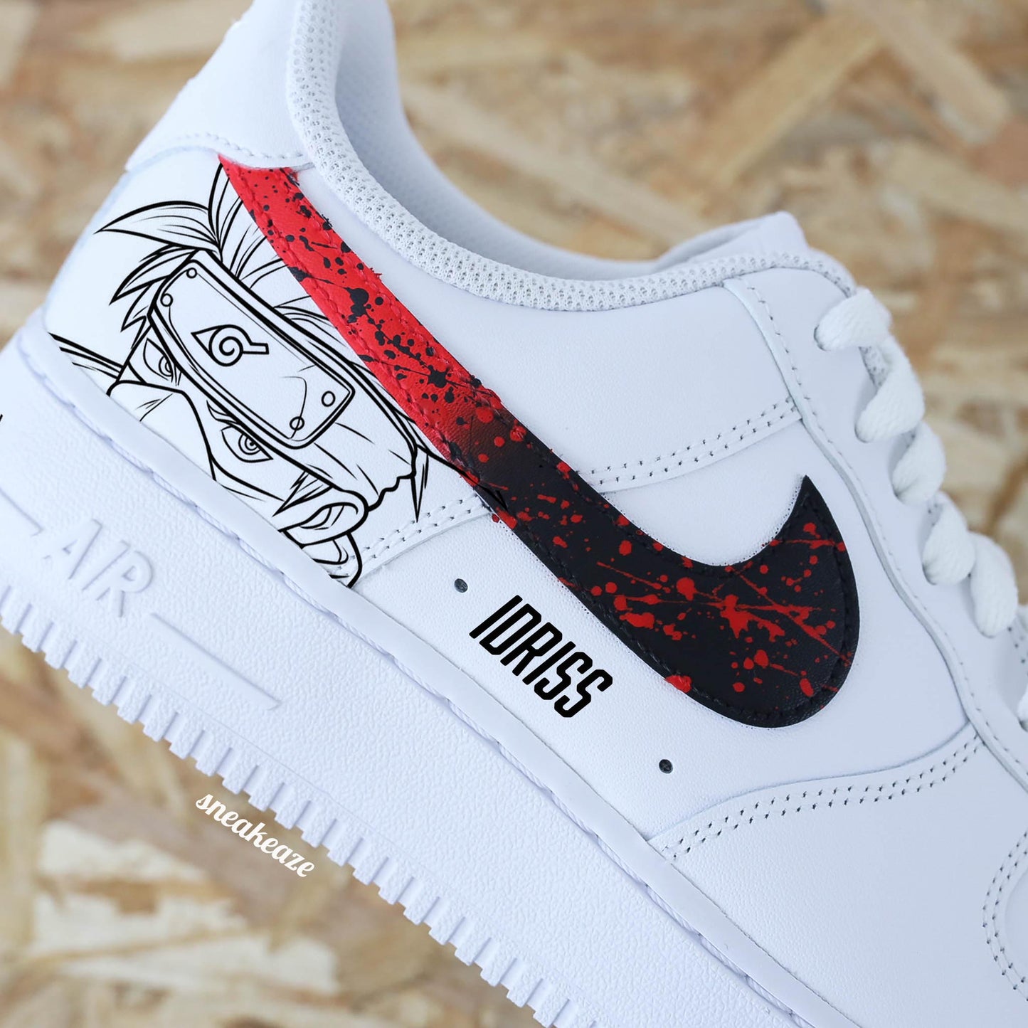 Baskets Nike Air force 1 custom motifs naruto sur côtés extérieurs. Signes Nike peints en dégradé rouge et noir avec splash assortis et prénom sous le sneakeaze custom