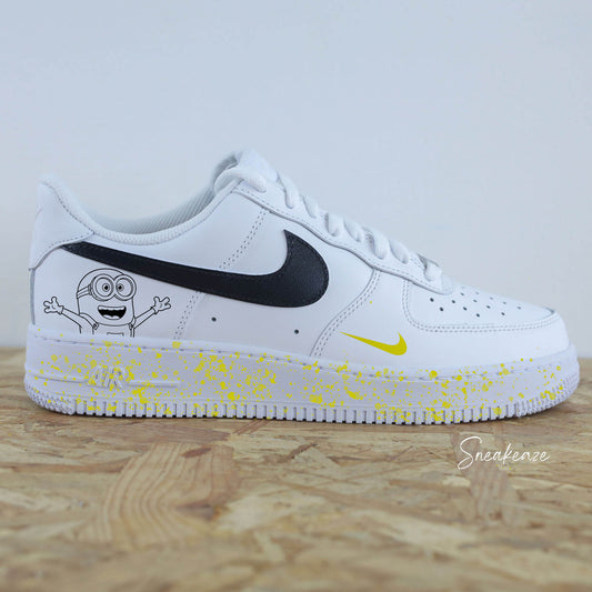 Baskets Nike Air Force 1 custom swoosh noir et dessin d'un minion sur côtés extérieurs. Splash jaune sur les semelles peint à la main sneakeaze customs