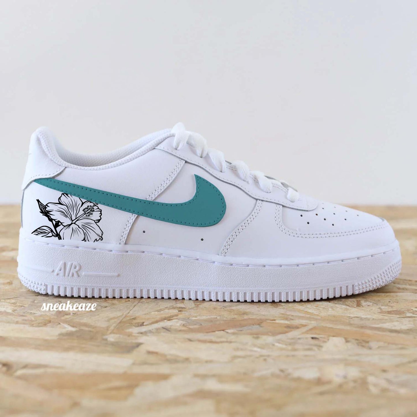 Baskets Nike Air Force 1 custom swoosh couleur turquoise pastel et dessin d'hibiscus sur les côtés extérieurs