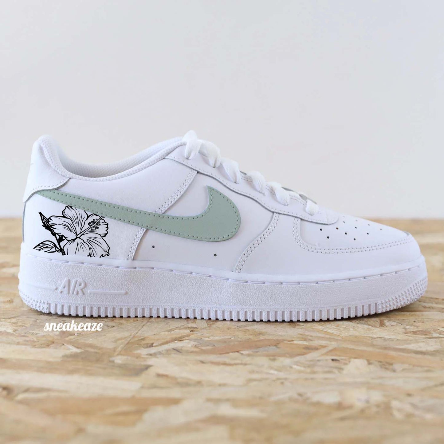 Baskets Nike Air Force 1 custom swoosh couleur vert de gris pastel et dessin d'hibiscus sur les côtés extérieurs