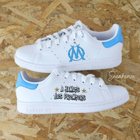 Active le vrai marseillais qui est en toi avec cette paire d'Adidas Stan smith custom aux couleurs de l'Olympique de Marseille. Démarque-toi avec une paire de sneakers originale et sors du lot avec cette personnalisation tout droit sorti du Vieux Port entre le quartier du Mistral de Plus belle la Vie et notre Dame de la Garde. Avec ces baskets aux pieds tu crains déguns comme Jul et SCH ! Droit au but ! Sneakeaze customs