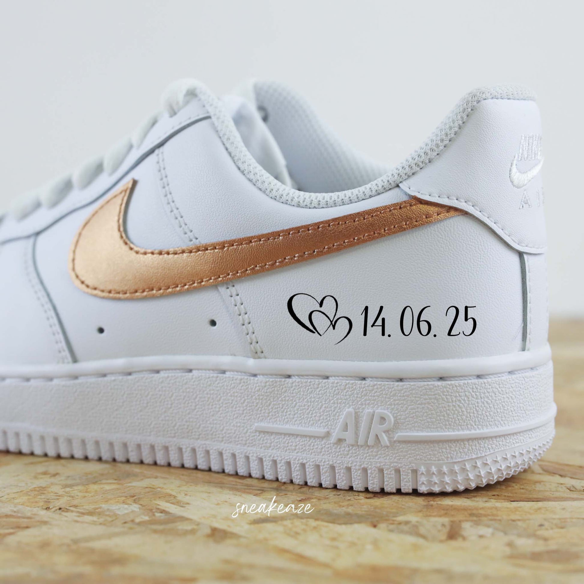 Nike Air Force 1 basses blanches en cuir personnalisées pour mariage, Démarquez-vous avec une paire de sneakers personnalisable avec l'inscription de vos prénoms et la date du jour J accompagné du signe nike en couleur bronze métallisé