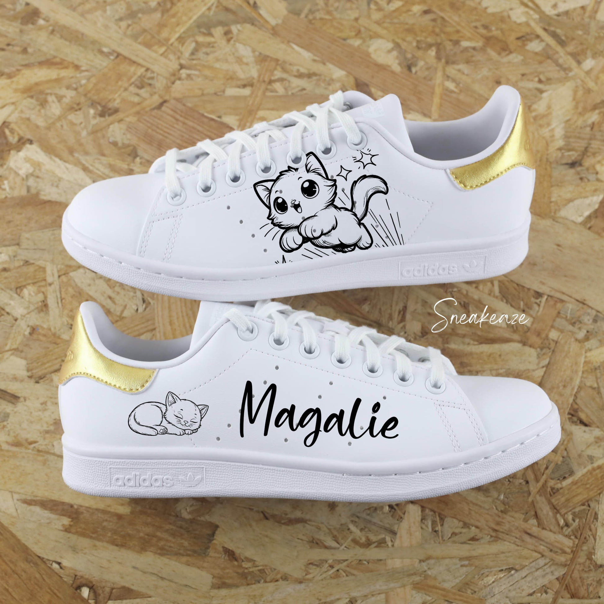 Baskets Adidas Stan Smith custom blanches avec dessin de chaton peint à la main et l'inscription du prénom pour enfant, le tout sur les côtés extérieurs. talon peint en doré