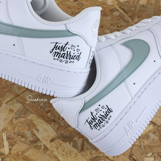 Nike Air Force 1 basses blanches en cuir custom, paire de sneakers pour mariage inscription de la phrase "just married" avec les initiales et la date du jour J à l'arrière des baskets. Sneakeaze customs - skz wedding 