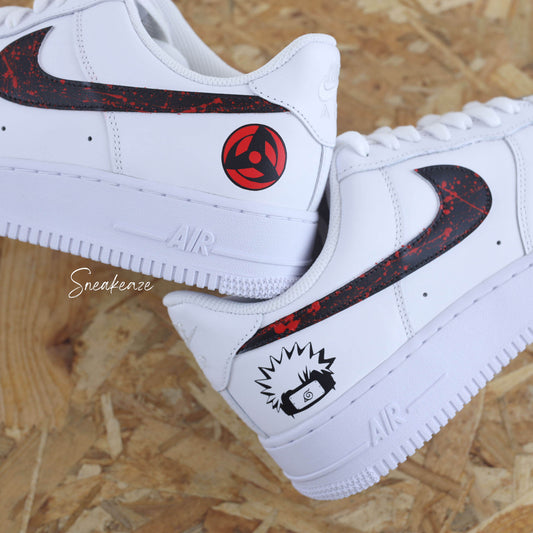 Nike Air Force 1 custom avec motifs Naruto sur les côtés extérieurs, swoosh noir et splash rouge intense — une paire unique pour les fans de manga et de sneakers.