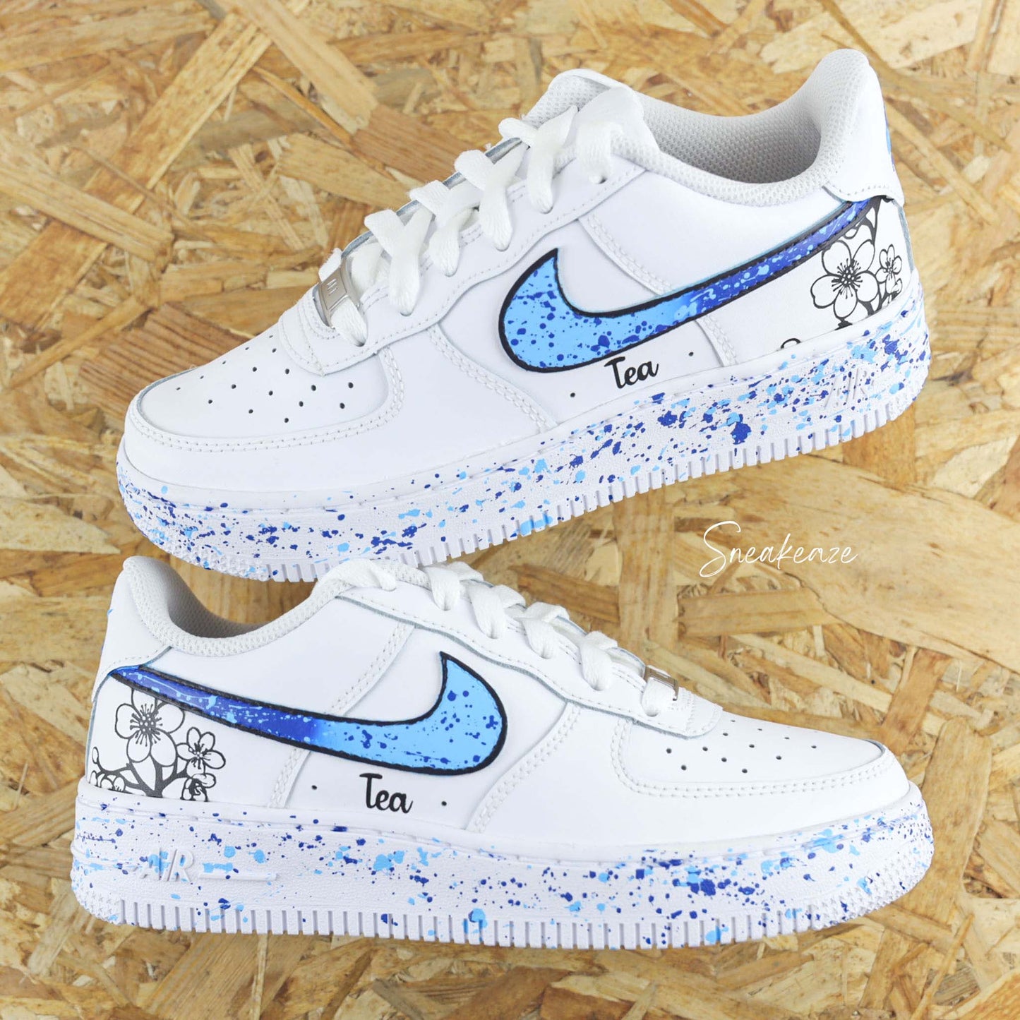 Baskets Nike Air force 1 custom motifs fleurs sur côtés extérieurs avec prénom. Signes Nike peints en dégradé bleu avec splash assortis sneakeaze customs