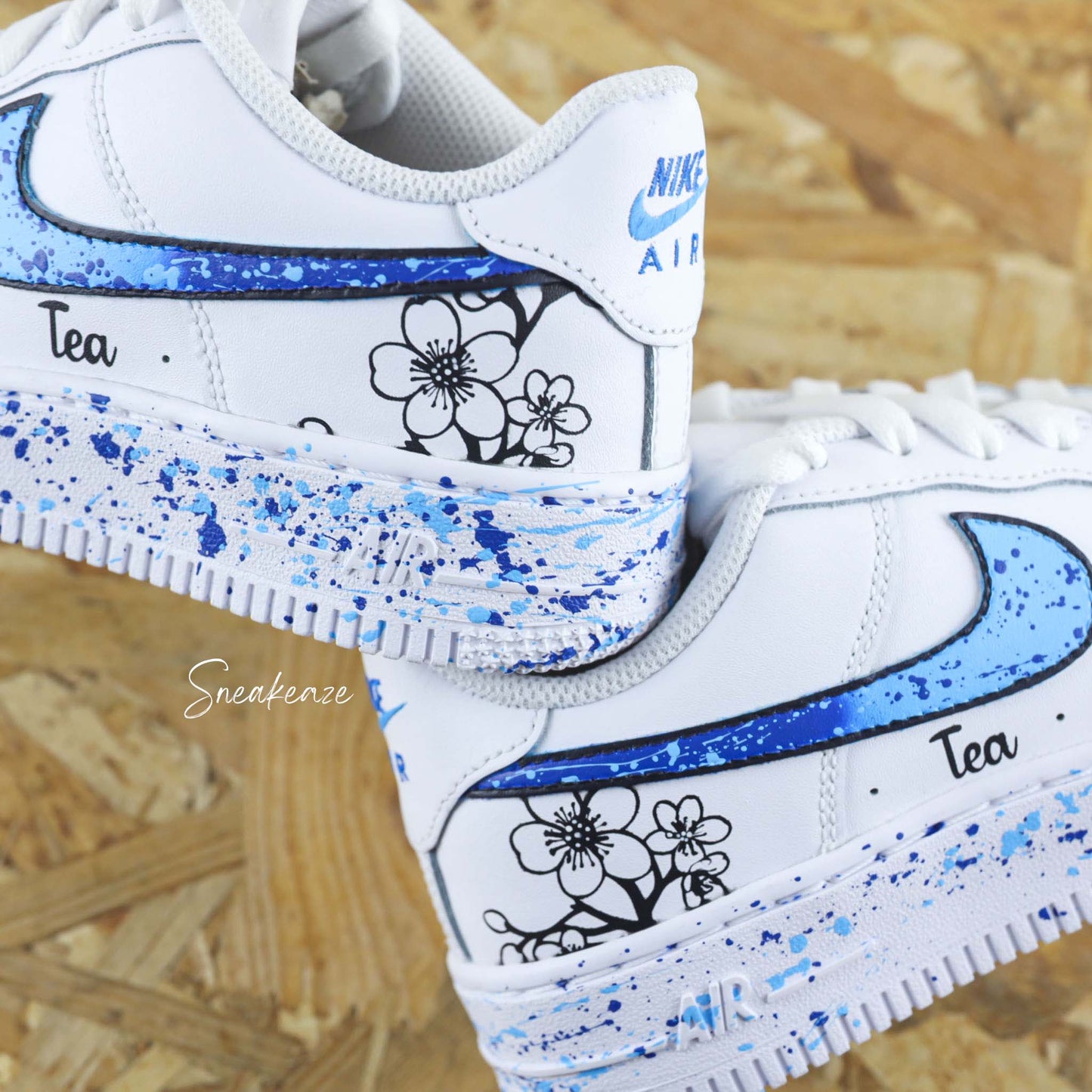Baskets Nike Air force 1 custom motifs fleurs sur côtés extérieurs avec prénom. Signes Nike peints en dégradé bleu avec splash assortis sneakeaze customs