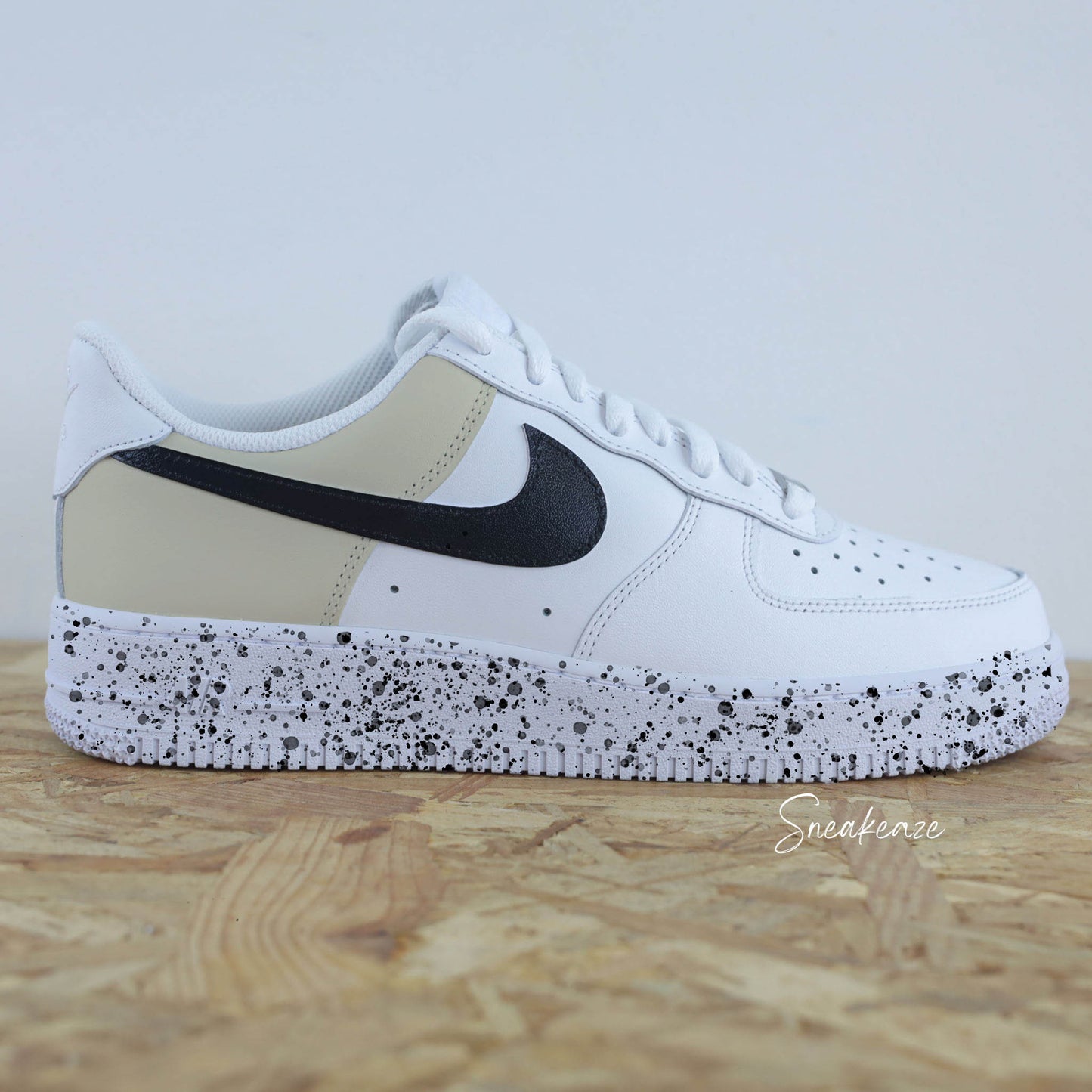 Basket Nike Air force 1 custom color block beige et noir. Signes Nike peint sur les 4 cotés en noir avec splash de peinture assortis sneakeaze custom