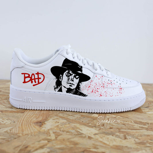 Baskets personnalisées Nike Air Force 1 inspirées de Michael Jackson. Peinture artisanale à la main avec portrait iconique et splash rouge moderne. Sneakers uniques et originales sneakeaze customs