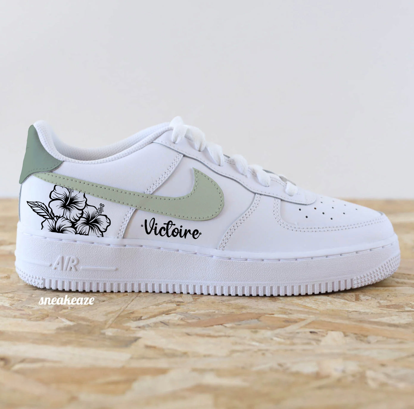 Baskets Nike Air Force 1 custom modèle swoosh vert sauge (les 4 côtés sont peints) et talon vert de gris + inscription d'un prénom et dessin de fleurs sneakeaze customs