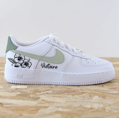 Baskets Nike Air Force 1 custom modèle swoosh vert sauge (les 4 côtés sont peints) et talon vert de gris + inscription d'un prénom et dessin de fleurs sneakeaze customs