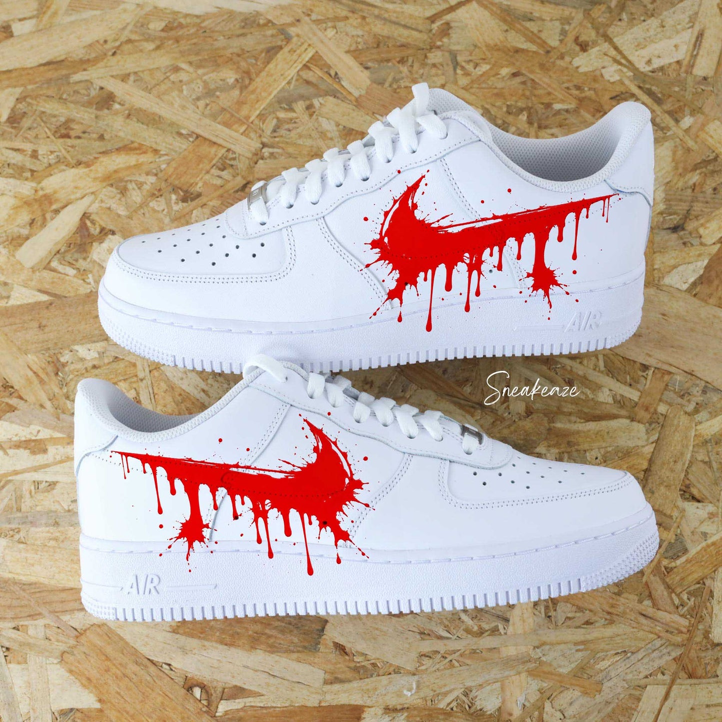 Paires de Nike Air Force 1 blanches customisées à la main par Sneakeaze Customs avec un effet Swoosh coulant rouge sang (drip).
