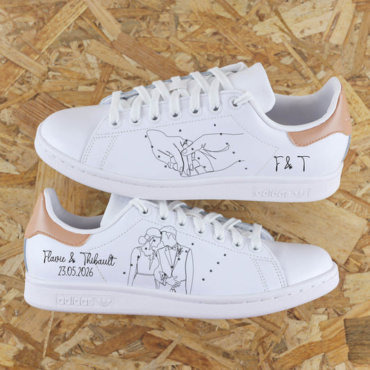 Baskets Adidas stan smith custom main dans la main avec inscription de la date du jour J, des prénoms et les initiales des mariés