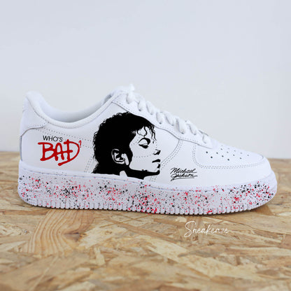 Baskets personnalisées Nike Air Force 1 inspirées de Michael Jackson. Peinture artisanale à la main avec portrait iconique et splash rouge moderne. Sneakers uniques et originales sneakeaze customs