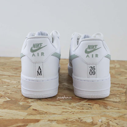 Nike Air Force 1 basses blanches en cuir custom, paire de sneakers pour mariage inscription de la phrase "just married" avec les initiales et la date du jour J à l'arrière des baskets. Sneakeaze customs - skz wedding 