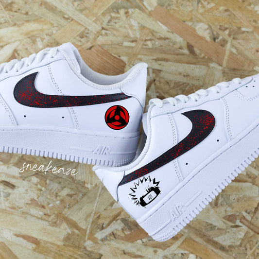 Découvrez la Nike Air Force 1 custom avec motifs Naruto sur les côtés extérieurs, swoosh noir et splash rouge intense — une paire unique pour les fans de manga et de sneakers.