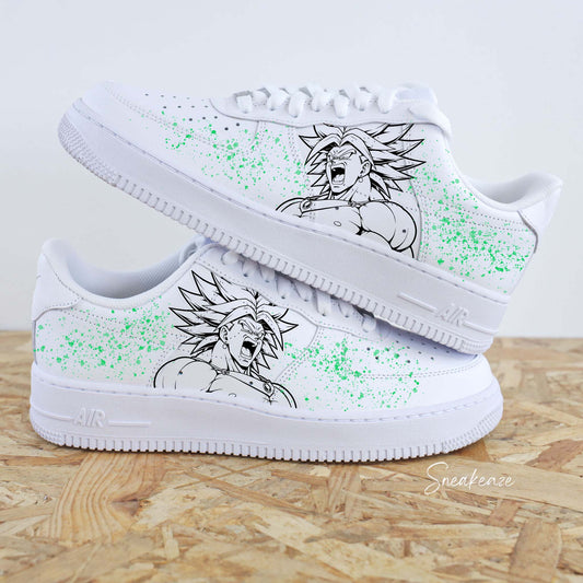 Paires de Nike Air Force 1 customisées par Sneakeaze Customs avec un dessin de Broly de Dragon Ball Z et des éclaboussures vertes. Nike custom manga pour homme baskets dbz goku