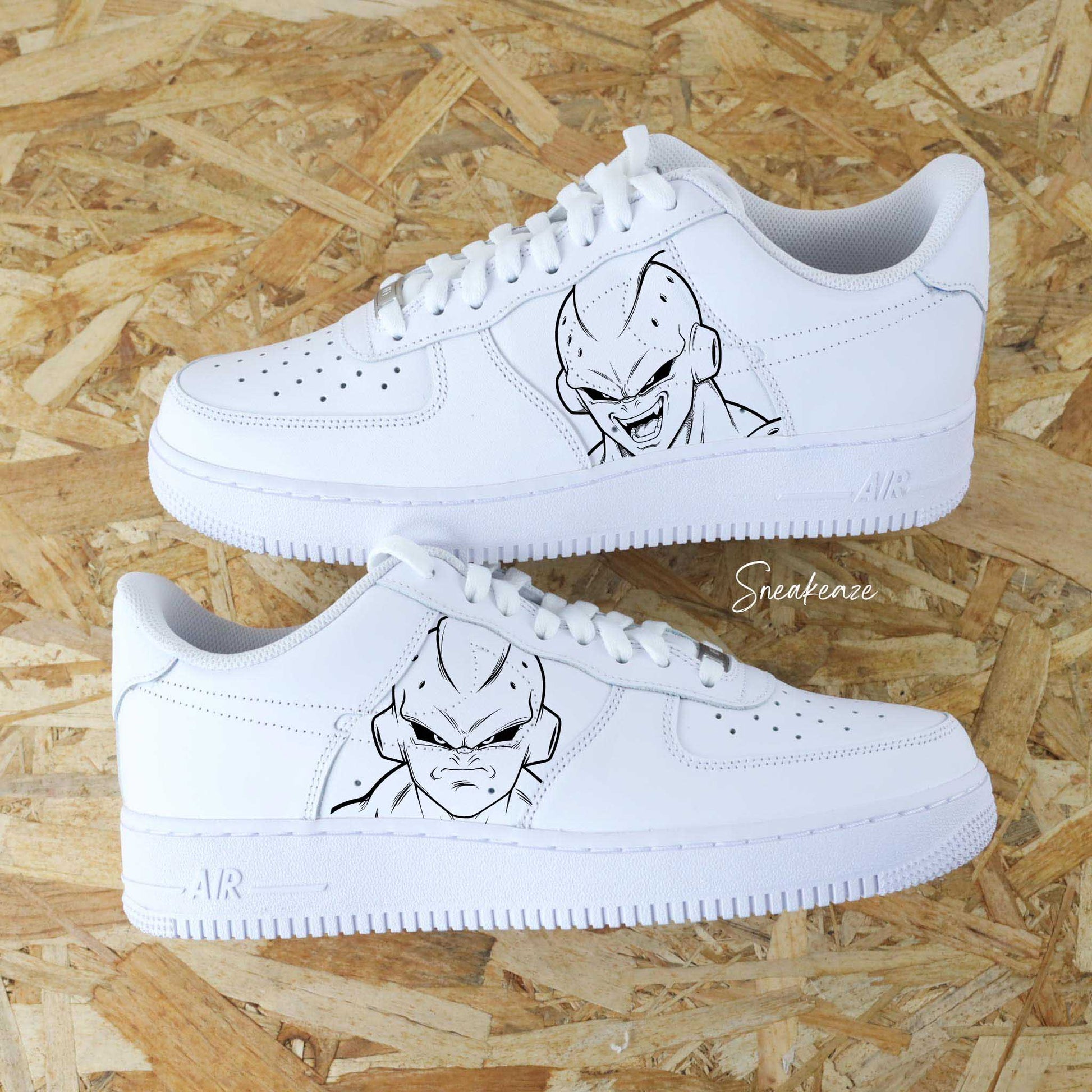 Paire de Nike Air Force 1 custom avec un portrait de Kid Buu dragon ball z et des éclaboussures roses et noires par Sneakeaze Customs nike custom dbz homme