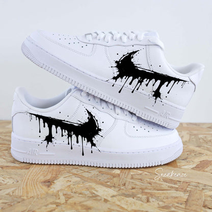 Paires de Nike Air Force 1 blanches customisées à la main par Sneakeaze Customs avec un effet Swoosh coulant noir (drip)